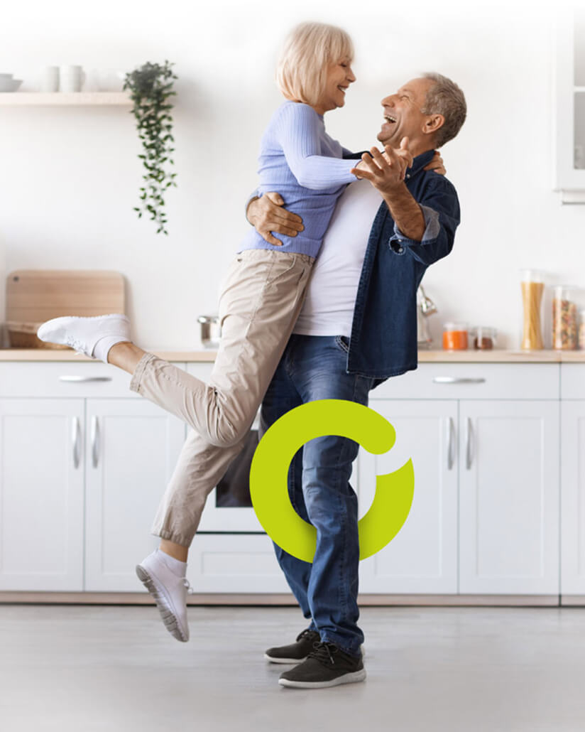 paar-tanzt-trotz-arthrose Ein älteres Paar tanzt in der Küche. Beide lächeln und sind glücklich.